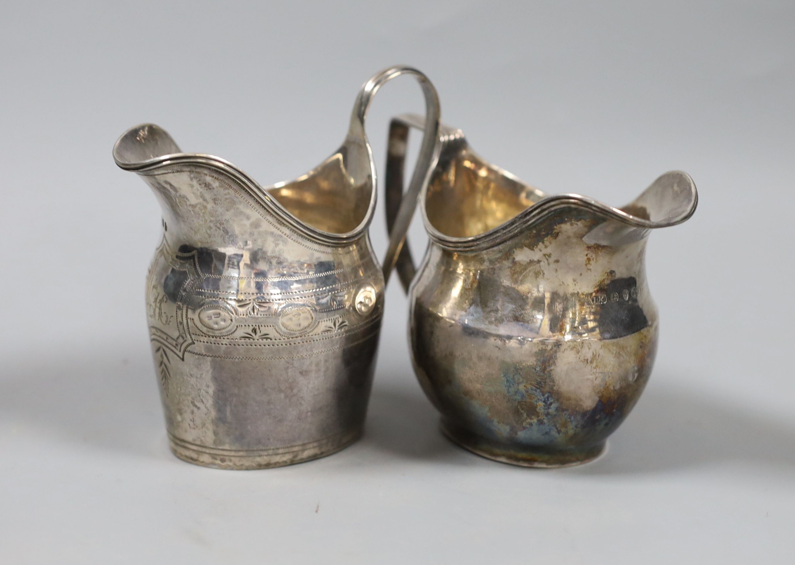 Two George III silver helmet shaped cream jugs, London, 1789 and London, 1796, tallest 10.6cm, 6.5oz.
